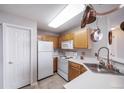 Efficient kitchen with white appliances and wooden cabinets at 8621 E Dry Creek Rd # 325, Englewood, CO 80112