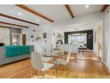 Open-concept dining area with modern furniture, hardwood floors, and decorative wooden beams at 11845 W 30Th Pl, Lakewood, CO 80215