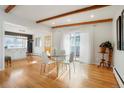 Dining room with hardwood floors, wood beams and adjacent kitchen access at 11845 W 30Th Pl, Lakewood, CO 80215