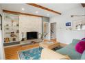 Open living room with hardwood floors, brick fireplace, and built-in shelving at 11845 W 30Th Pl, Lakewood, CO 80215