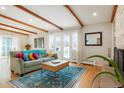 Bright living room featuring exposed wood beams, a comfortable sofa, and natural light at 11845 W 30Th Pl, Lakewood, CO 80215