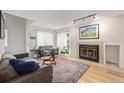 Cozy living room with a fireplace, two sofas, light hardwood floors, and ample natural light at 10290 W Jewell Ave # B, Lakewood, CO 80232