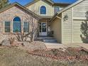 House entrance with brick and siding exterior, landscaping, and a walkway at 1663 Devils Point Pl, Highlands Ranch, CO 80126