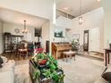 Spacious living room features high ceilings, a piano, and hardwood floors at 1663 Devils Point Pl, Highlands Ranch, CO 80126