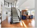 Welcoming foyer with hardwood floors, staircase, and an open view to the dining room at 8903 Edgewood St, Highlands Ranch, CO 80130