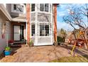 View of the brick patio with a porch swing and entrance to the home at 8903 Edgewood St, Highlands Ranch, CO 80130