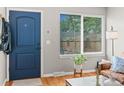 Welcoming entryway boasts beautiful blue door, hardwood floors, natural light, and a coat rack at 2854 N Lowell Blvd, Denver, CO 80211