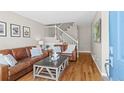 Inviting living room features hardwood floors, staircase with white railing, and comfortable seating at 2854 N Lowell Blvd, Denver, CO 80211