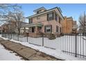 Charming brick home featuring a covered front porch, a well-kept yard and metal perimeter fence at 201 S Logan St, Denver, CO 80209