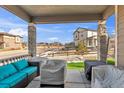 Relax on the covered patio with ample seating and view of fenced in yard at 9694 Truckee St, Commerce City, CO 80022