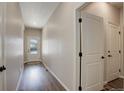 Inviting hallway featuring neutral walls, wood-look floors, and a front door letting in natural light at 8861 Ventura St, Commerce City, CO 80022