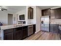 Kitchen featuring stainless steel appliances, granite countertops, and dark brown cabinets at 8861 Ventura St, Commerce City, CO 80022