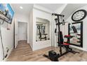Basement gym featuring modern workout equipment, wood floors, recessed lighting, and large mirror at 2922 W 26Th Ave # 1, Denver, CO 80211