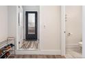 Entryway with wood floors, access to the downstairs powder room, and view of the frosted glass front door at 2922 W 26Th Ave # 1, Denver, CO 80211