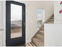 Welcoming entryway featuring a frosted glass door, staircase with carpet runner, and neutral paint at 2922 W 26Th Ave # 1, Denver, CO 80211