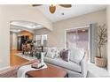 Open floor plan of living room adjacent to kitchen and dining area with vaulted ceiling and fan at 9804 Martin Luther King Blvd, Denver, CO 80238