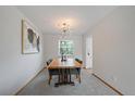 Modern dining room with stylish light fixture and a wooden table set for four at 10961 Gray Cir, Westminster, CO 80020