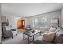Bright living room featuring a large window, plush seating, and a warm wood door at 10961 Gray Cir, Westminster, CO 80020