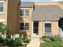 Charming townhome featuring manicured lawn, mature trees, and colorful flowerbeds enhancing the curb appeal at 13187 E Bethany Pl, Aurora, CO 80014