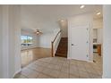 Inviting entryway with tile flooring, stairs, and a bright view into the adjacent living room at 11811 E Maplewood Ave, Englewood, CO 80111