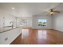 Sunlit living room with hardwood floors, open layout, and a view of the deck at 11811 E Maplewood Ave, Englewood, CO 80111