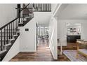 Bright foyer featuring hardwood floors, a staircase with black banister, and views of the living spaces at 5795 S Pagosa Way, Centennial, CO 80015