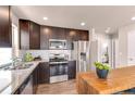 Modern kitchen features stainless steel appliances, granite countertops, and wooden cabinets at 46550 Avery Ln, Bennett, CO 80102