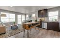 Open-concept living space with a large window, an electric fireplace, and wood kitchen island seating at 46550 Avery Ln, Bennett, CO 80102