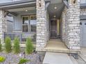 Charming front porch with stone columns, decorative lighting, and a cozy entrance at 2967 S Quaker St, Morrison, CO 80465
