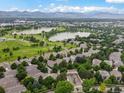 Expansive aerial view shows the neighborhood's proximity to a lush green golf course and serene lakes at 6700 W Dorado Dr # 47, Littleton, CO 80123