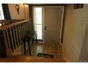 Inviting foyer featuring tiled floor, wooden staircase, and a charming welcome mat at 1936 S Poplar St, Denver, CO 80224