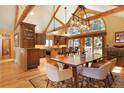 Open concept dining room adjacent to a kitchen with wood cabinetry and island seating at 25952 Fern Gulch Rd, Evergreen, CO 80439
