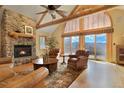 Cozy living room featuring a stone fireplace, vaulted ceiling, and mountain views at 25952 Fern Gulch Rd, Evergreen, CO 80439