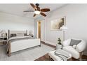 Cozy bedroom with wood-look ceiling fan, hardwood floors, and comfortable seating area at 1820 Newland Ct # 210, Lakewood, CO 80214