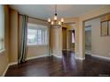 Formal dining area with hardwood floors, chandelier, and natural light streaming through large window at 25994 E Peakview Pl, Aurora, CO 80016