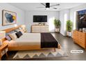Brightly lit bedroom featuring a ceiling fan, dark wood flooring, and modern decor. (Virtually Staged) at 19512 E 58Th Dr, Aurora, CO 80019