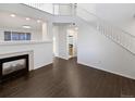Bright living room featuring a fireplace and dark wood flooring, complemented by neutral walls at 19512 E 58Th Dr, Aurora, CO 80019