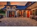 A covered stone patio with seating and stone accents gives access to the home's interior through sliding glass doors at 5166 Bear Mountain Dr, Evergreen, CO 80439