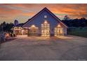 Stunning home showcasing modern garage doors and meticulous landscaping at sunset at 5166 Bear Mountain Dr, Evergreen, CO 80439