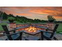 A cozy outdoor fire pit features a stone surround with built-in seating and lovely backyard views at 5166 Bear Mountain Dr, Evergreen, CO 80439