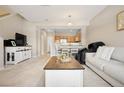 Bright living room with neutral decor, carpet, and a view into the kitchen at 17922 E 104Th Pl # D, Commerce City, CO 80022