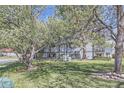 Exterior view of a light blue condo building surrounded by mature trees and well-maintained lawn at 3363 Oneal Pkwy # 36, Boulder, CO 80301