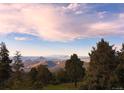 Scenic mountain view showcasing rolling hills and distant peaks under a cloudy sky at 13954 Pine Country Ln, Conifer, CO 80433