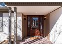 Stylish front door features a glass insert and sidelights, set in a covered entrance with brick accents at 3975 S Cherry St, Cherry Hills Village, CO 80113