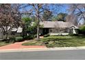 Charming single-story home with well-maintained landscaping, mature trees, and a brick driveway at 3975 S Cherry St, Cherry Hills Village, CO 80113