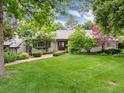 Charming single-story home featuring a lush front yard, brick pathway, and meticulously landscaped garden beds at 3975 S Cherry St, Cherry Hills Village, CO 80113