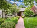 Charming single-story home featuring a lush front yard, brick pathway, and meticulously landscaped garden beds at 3975 S Cherry St, Cherry Hills Village, CO 80113