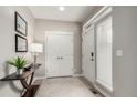 Bright entryway with white door, double coat closet, table and modern lamp at 16762 Tejon Ln, Broomfield, CO 80023