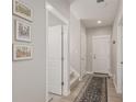 Hallway with an open door that reveals carpeted stairs and three framed wall pictures at 16762 Tejon Ln, Broomfield, CO 80023