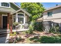 Charming front patio with brick pathway, lush landscaping and comfortable wicker seating area at 10957 Bryant St, Westminster, CO 80234